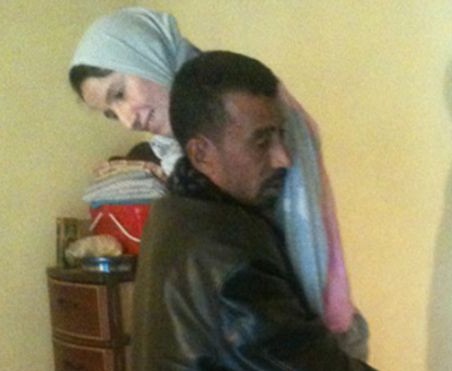 بالصور جزائري يحمل زوجته على كتفيه منذ 5 سنوات بعد إصابتها بشلل 