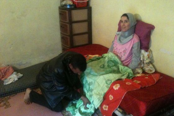 بالصور جزائري يحمل زوجته على كتفيه منذ 5 سنوات بعد إصابتها بشلل 